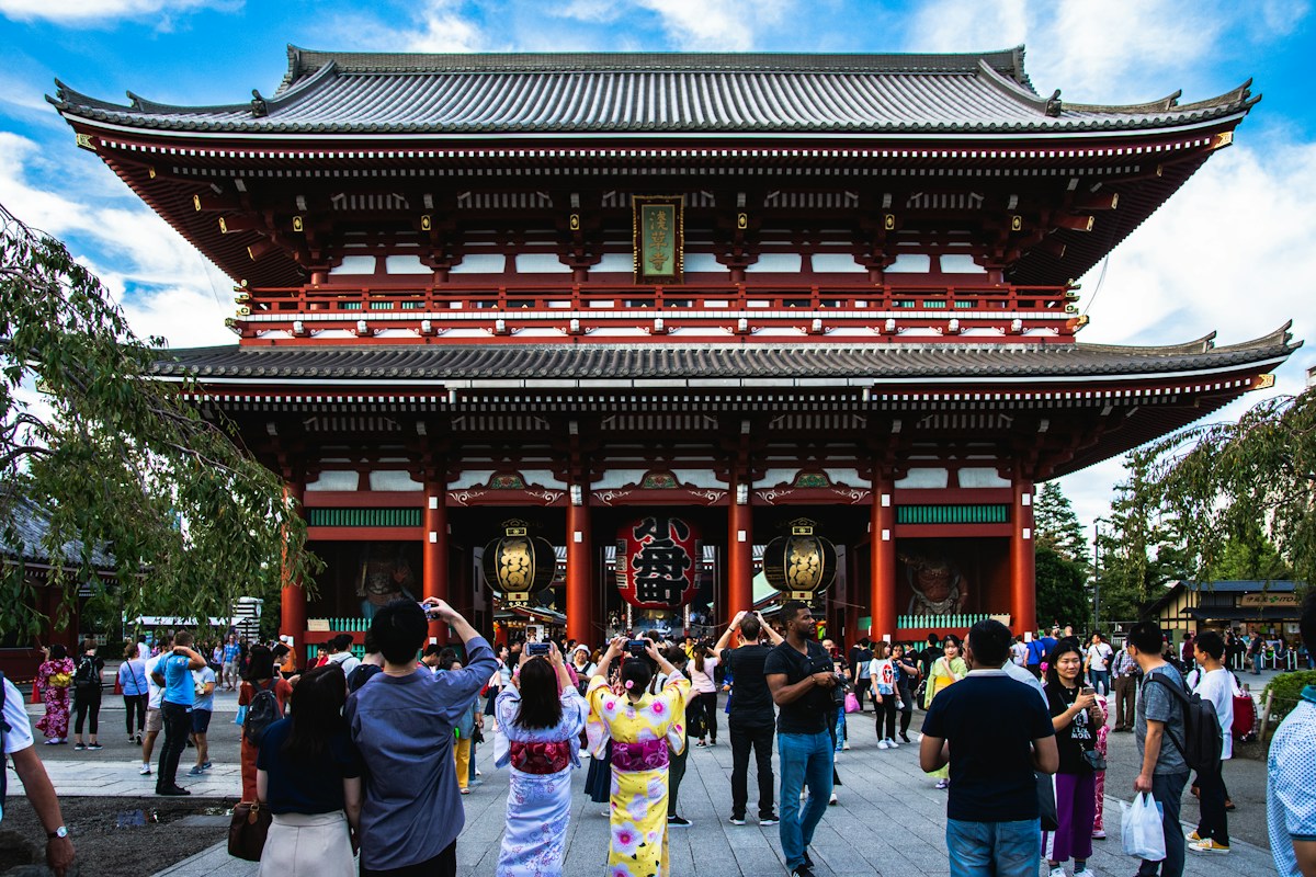 浅草寺の朱色の門と境内を歩く人々